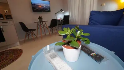 a living room with a blue couch and a table with a plant at City Life Metro Ambelokipi in Athens