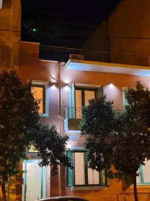 a building with lights on the side of it at night at City Life Metro Ambelokipi in Athens