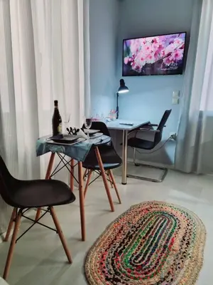 a living room with a table and chairs and a tv at City Break Metro Ambelokipi in Athens