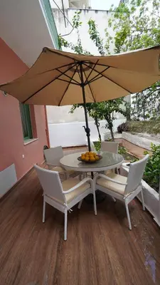 a table and chairs with an umbrella on a patio at City Break Metro Ambelokipi in Athens