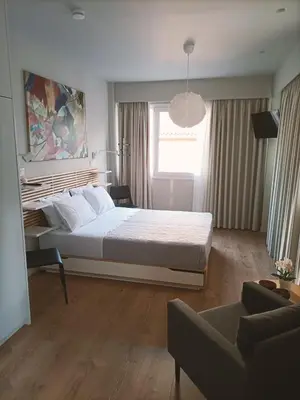 a bedroom with a large bed and a couch at Historic Center Luxury Studio Apartment in Athens
