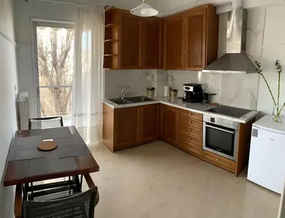 a kitchen with wooden cabinets and a table and a sink at The Temple of Comfort in Athens