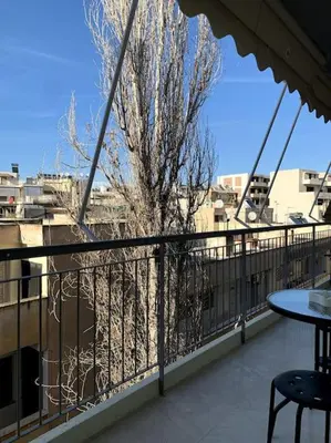 a balcony with a table and a tree on it at The Temple of Comfort in Athens