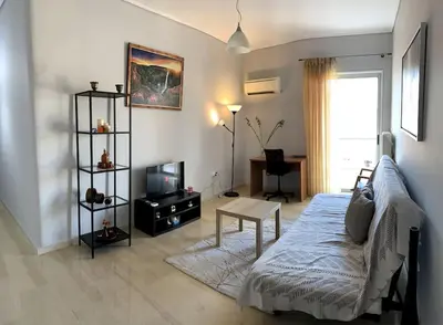 a living room with a bed and a table and a tv at The Temple of Comfort in Athens