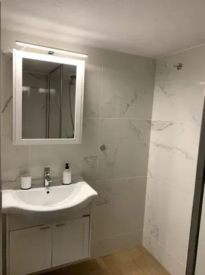 a white bathroom with a sink and a mirror at The Temple of Comfort in Athens