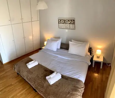 a bedroom with a large bed with two towels on it at The Temple of Comfort in Athens