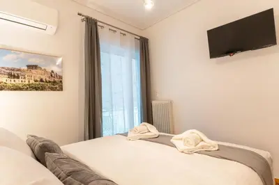 a bedroom with a bed and a tv on the wall at Acropolis Luxurious Legacy in Athens