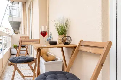 a small table with two chairs and a glass of wine at Acropolis Luxurious Legacy in Athens