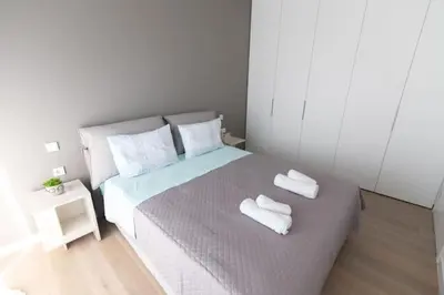 a bedroom with a bed with two white towels on it at Bright apartment in the New building (FORM_F1) in Athens
