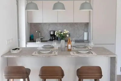 a kitchen with a counter with two chairs and a counter top at Bright apartment in the New building (FORM_F1) in Athens
