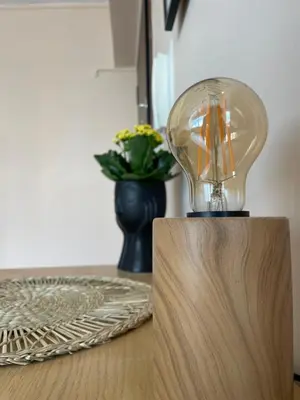 a light bulb on a table with a vase of flowers at Modern Cityview Flat - 1 min to Metro - Walk to Acropolis in Athens