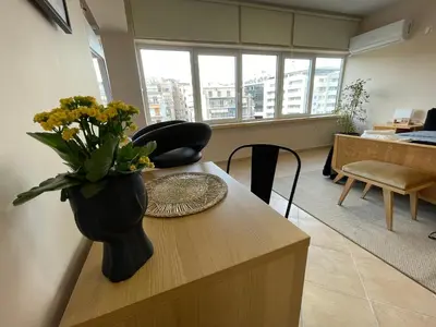 a vase of flowers on a table in a living room at Modern Cityview Flat - 1 min to Metro - Walk to Acropolis in Athens