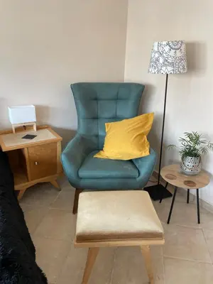 a blue chair with a yellow pillow in a living room at Modern Cityview Flat - 1 min to Metro - Walk to Acropolis in Athens