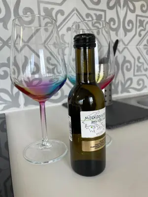 a bottle of wine next to two wine glasses at Modern Cityview Flat - 1 min to Metro - Walk to Acropolis in Athens