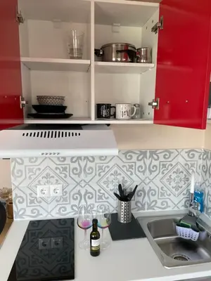 a kitchen with a sink and a red cabinet at Modern Cityview Flat - 1 min to Metro - Walk to Acropolis in Athens