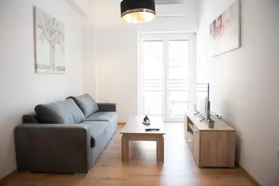 a living room with a couch and a table at Cozy flat 5min to subway station (EPIDAMN) in Athens