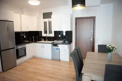 a kitchen with white cabinets and a table with chairs at Cozy flat 5min to subway station (EPIDAMN) in Athens
