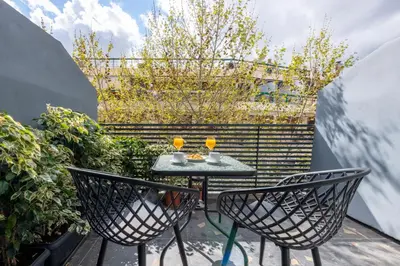 a patio with two chairs and a table on a balcony at Furla Suites Athens in Athens