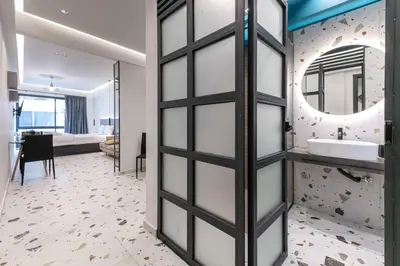 a bathroom with a sliding door leading to a bedroom at Furla Suites Athens in Athens