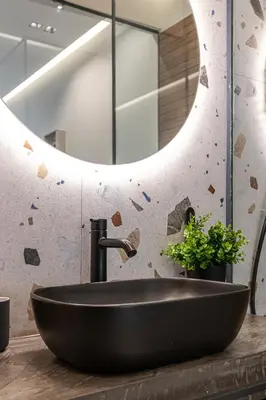 a bathroom with a black sink and a mirror at Furla Suites Athens in Athens