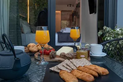 a table with bread and two glasses of orange juice at Furla Suites Athens in Athens