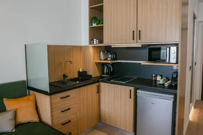 a kitchen with wooden cabinets and a sink and a dishwasher at Sun Marco Apartments in Athens in Athens