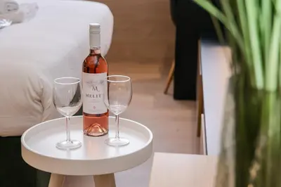 a bottle of wine and two wine glasses on a table at Sun Marco Apartments in Athens in Athens