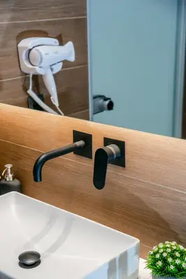 a bathroom sink with a faucet and a mirror at Sun Marco Apartments in Athens in Athens