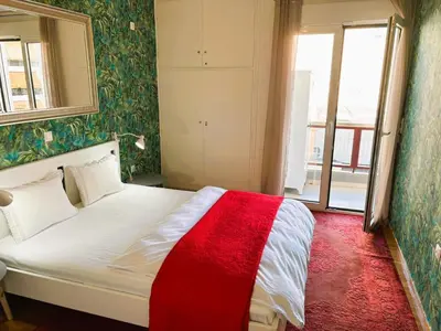 a bedroom with a bed with a red blanket on it at Apartament Athina in Athens