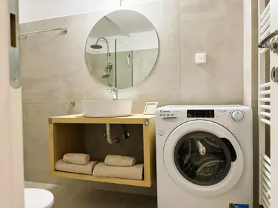 a bathroom with a washing machine and a mirror at Apartament Athina in Athens