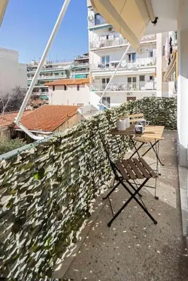 a table and chair on the balcony of a building at Filoxenia MG Projects city center in Athens