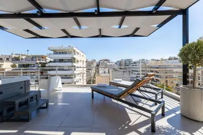 a balcony with a bench and a chair on a roof at Jacuzzi Luxpenthouse PFaliro in Athens
