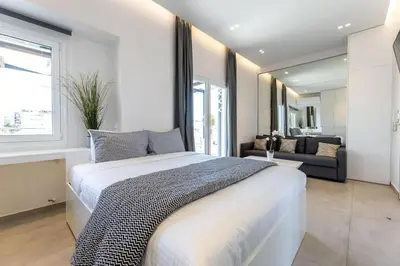 a bedroom with a large bed and a couch at Jacuzzi Luxpenthouse PFaliro in Athens