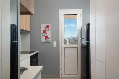 a kitchen with a refrigerator and a window at Jacuzzi Luxpenthouse PFaliro in Athens