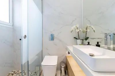 a white bathroom with a sink and a toilet at Jacuzzi Luxpenthouse PFaliro in Athens