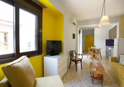a living room with a couch and a tv and a table at Live in Athens, PSYRRI Meet Me Here Apartments in Athens