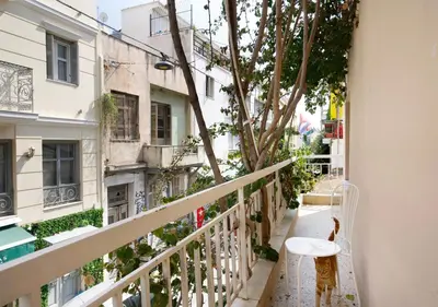 a balcony with a white bench and a tree at Live in Athens, PSYRRI Meet Me Here Apartments in Athens
