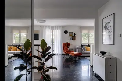 a living room with a plant in the middle at The Black Marble - Sea View, 2BR, 2BA in Paleo Faliro in Athens