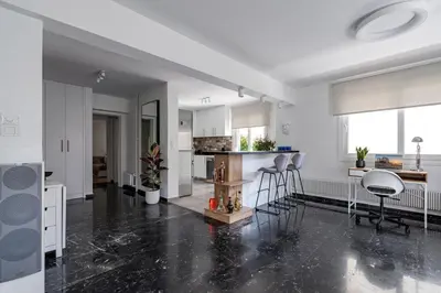 an open kitchen with white cabinets and bar stools at The Black Marble - Sea View, 2BR, 2BA in Paleo Faliro in Athens