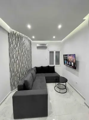 a living room with a black couch and a table at ATH Luxury Central apartment in Athens