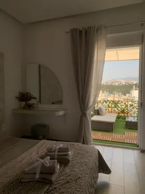 a bedroom with a bed and a view of a patio at Luxury Athens Apartment with Breathtaking Views in Athens