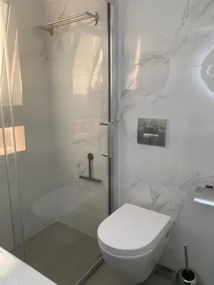 a white bathroom with a toilet and a shower at Luxury Athens Apartment with Breathtaking Views in Athens