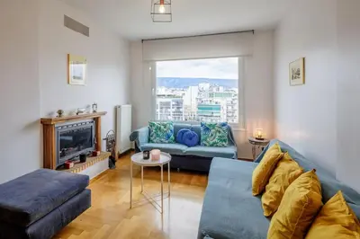 a living room with a blue couch and a fireplace at City view roof top apt 10min from Acropolis museum in Athens