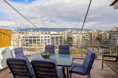 a table and chairs on a balcony with a view at City view roof top apt 10min from Acropolis museum in Athens