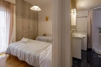 a bedroom with two beds and a sink and a bathroom at City view roof top apt 10min from Acropolis museum in Athens