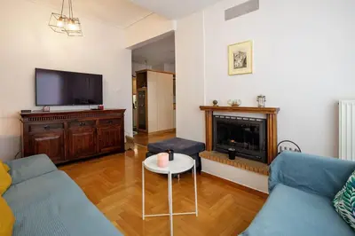 a living room with a couch and a fireplace at City view roof top apt 10min from Acropolis museum in Athens