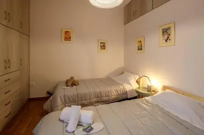 a bedroom with two beds and a teddy bear sitting on the bed at City view roof top apt 10min from Acropolis museum in Athens