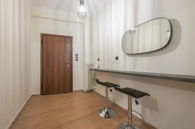 a bathroom with a mirror and a counter with two stools at Athens center spacious apartment in Athens