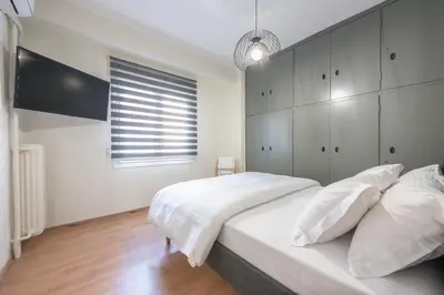 a bedroom with a large white bed and a window at Athens center spacious apartment in Athens