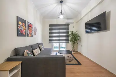 a living room with a couch and a tv at Athens center spacious apartment in Athens